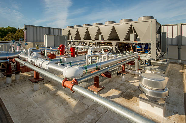 Rooftop HVAC With Chillers Rooftop HVAC including chiller towers, insulated pipes and circulating pumps. chiller hvac equipment photos stock pictures, royalty-free photos & images