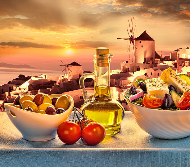Greek salad in Santorini island, Greece Greek salad in Santorini island against famous windmills, Oia, Greece table ledge stock pictures, royalty-free photos & images