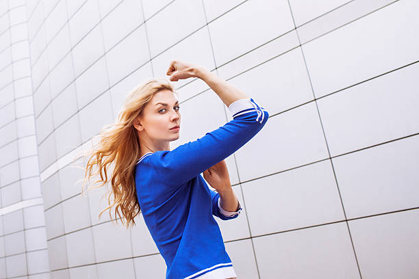 joven mujer mostrando su fuerza  - human muscle women bicep girl power fotografías e imágenes de stock