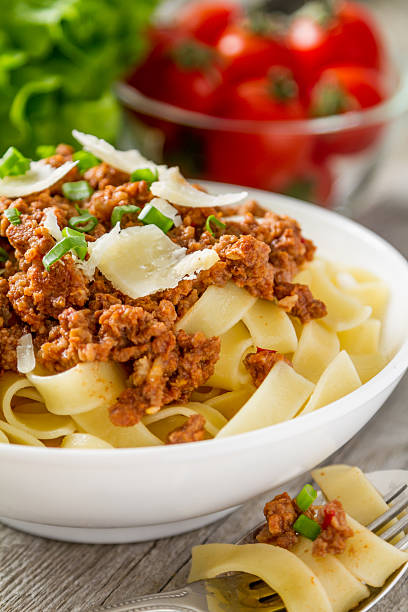 istock Pasta bolognese in white bowl with salad and tomatoes 474427404