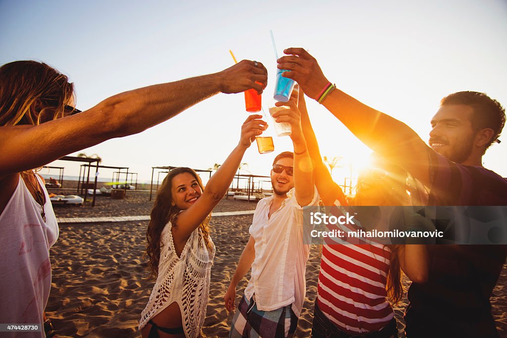 Friends on the beach having toast Group of friends having fun on a sunny day and toasting with drinks 20-24 Years Stock Photo
