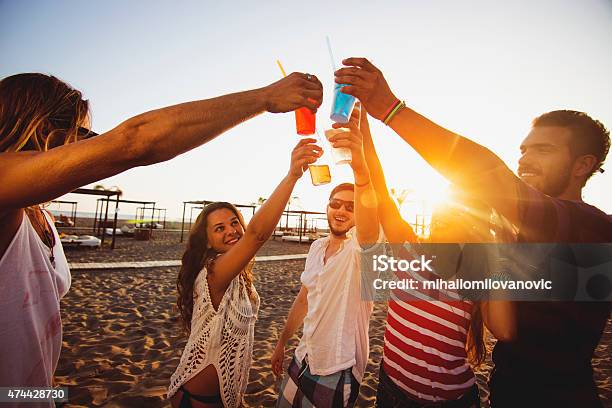 Friends On The Beach Having Toast Stock Photo - Download Image Now - 20-24 Years, 2015, 30-34 Years