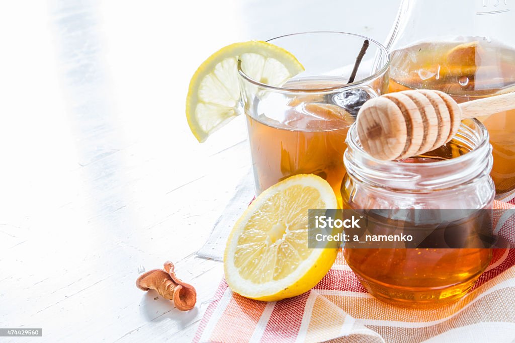 Traditional ukrainian drink in glass with honey, lemon Traditional ukrainian drink in glass with honey, lemon, white wood background 2015 Stock Photo