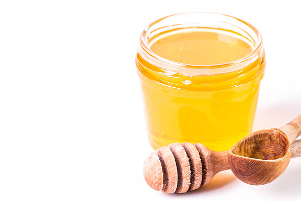 istock Honey dipper on the bee honeycomb background. 474435462
