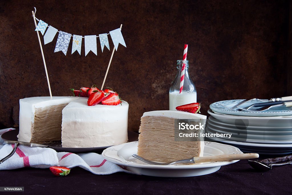 Crepe cake Napoleon with strawberries Piece of Crepe cake Napoleon with strawberries and decorated with flag Layer Cake Stock Photo