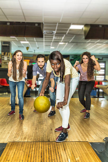 istock Young black woman playing bowling with friends 474444652