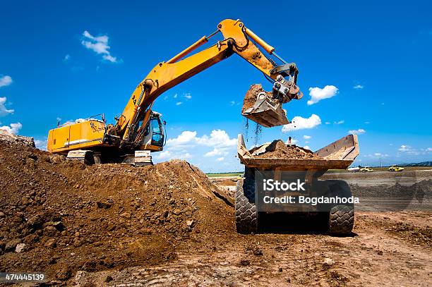 Foto de Caminhões Industriais Carregando Excavator Em Terra E Descarga Int e mais fotos de stock de Obra