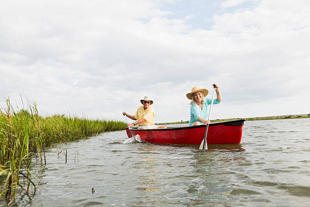 istock Senior couple rowing canoe on calm lake 474446565