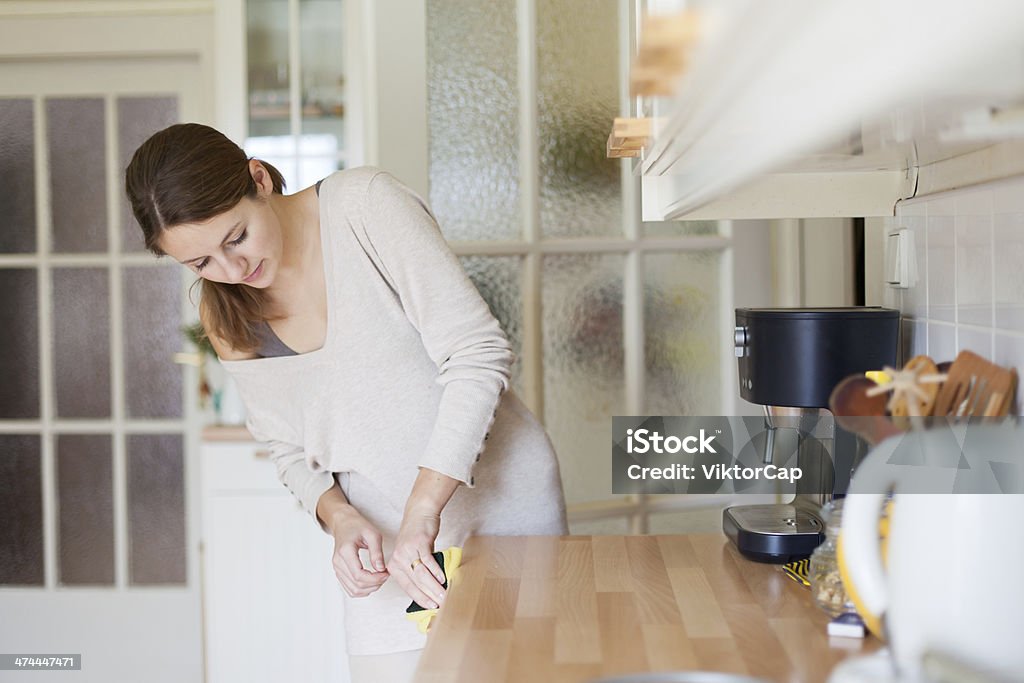 Young woman doing housework, cleaning the kitchen Clean Stock Photo