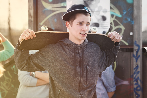 Portrait of teenage skater boy with a skateboard