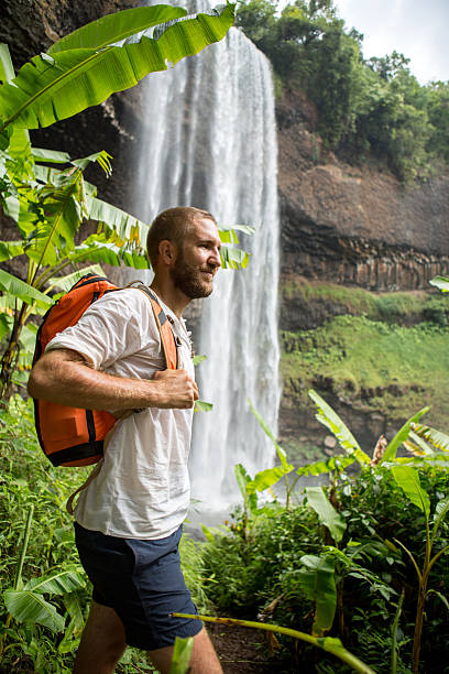 istock Beard man hiking in jungle, waterfall on background 474451256