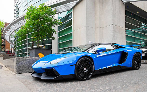 Montreal, Quebec, Canada - May 16, 2015: Parked in front of a hotel, a Lamborghini Aventador LP700-4.  Hotel facade in background with another vehicle slightly visible behind.  The Aventador is the replacement for the Murcielago and contains many visual clues similar to Lamborghini's limited-edition Reventón.