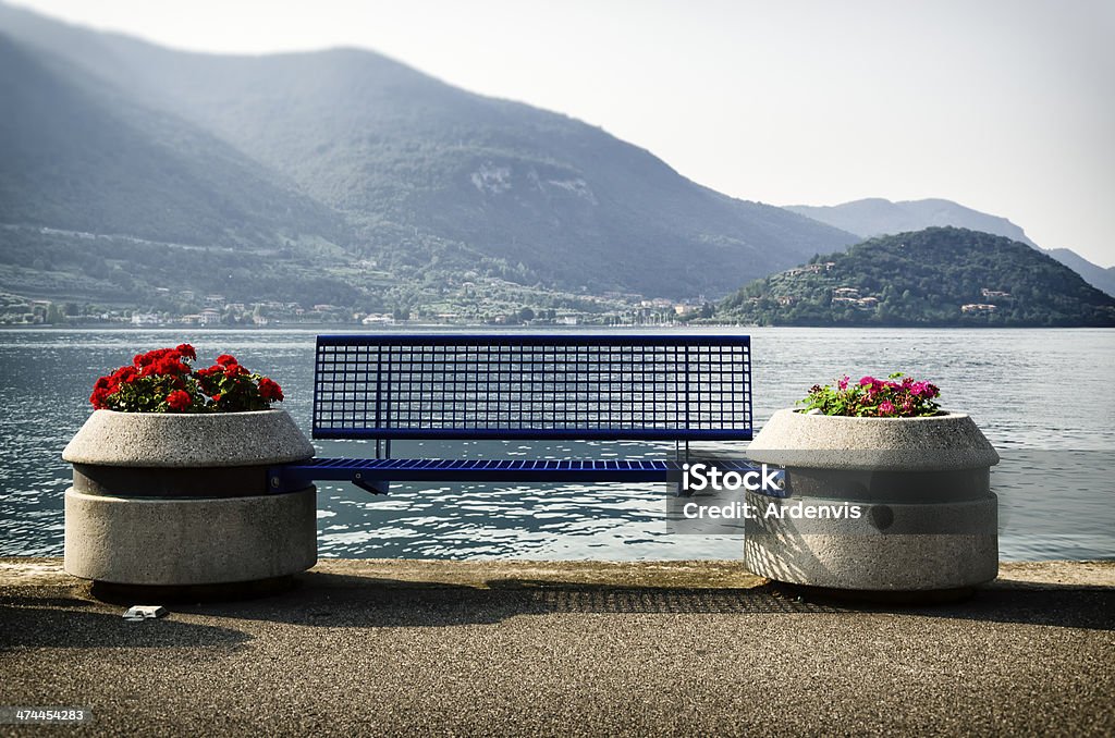 Panca e fiori di fronte lago d'Iseo, Monte Isola d'Istria - Foto stock royalty-free di Acqua
