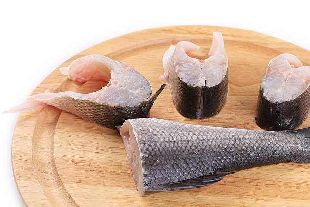 istock Steaks and tail of seabass on wooden platter. 474455949