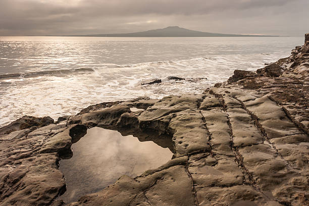 Takapuna beach at sunset Takapuna beach with Rangitoto island in New Zealand at sunset rangitoto island stock pictures, royalty-free photos & images