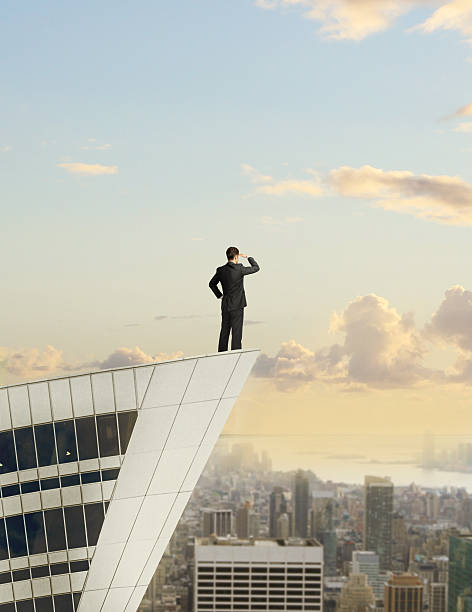 istock businessman standing on roof 474460947