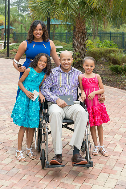 Family with disabled father on their way to church stock photo