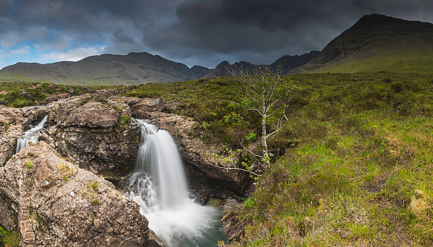 istock Waterfalls cascading down mountain valley from jagged peak panorama Scotland 474468393