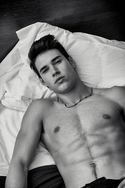 istock Attractive shirtless athletic young man laying in bed at night 474470028