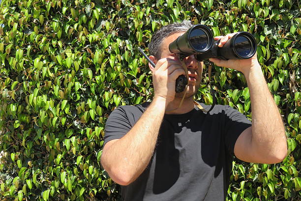 istock man talking on the walkie-talkie, looking through binoculars 474475580