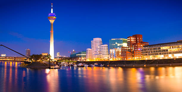 Colorful night scene of Rhein river at night in Dusseldorf Colorful night scene of Rhein river at night in Dusseldorf. Rheinturm tower in the soft night light, Nordrhein-Westfalen, Germany, Europe. media harbor photos stock pictures, royalty-free photos & images