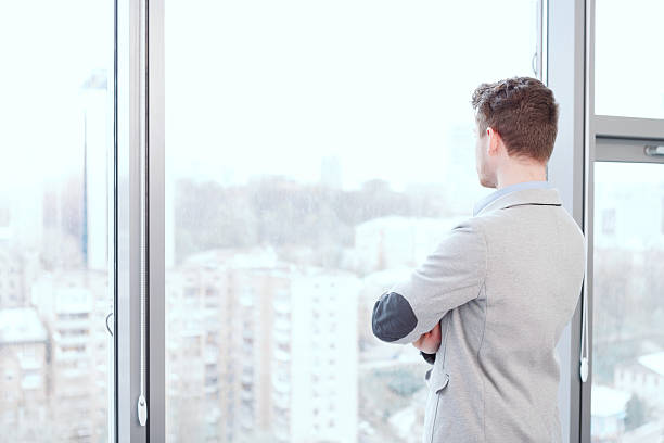 istock Portrait of man looking in window 474477214