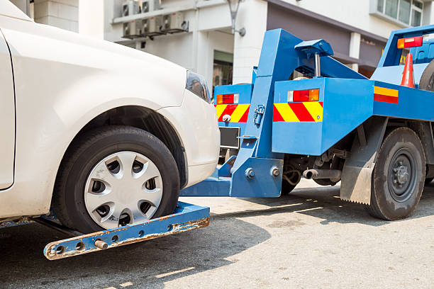 Tow truck towing a broken down car on the street Tow truck towing a broken down car on the street tow truck stock pictures, royalty-free photos & images