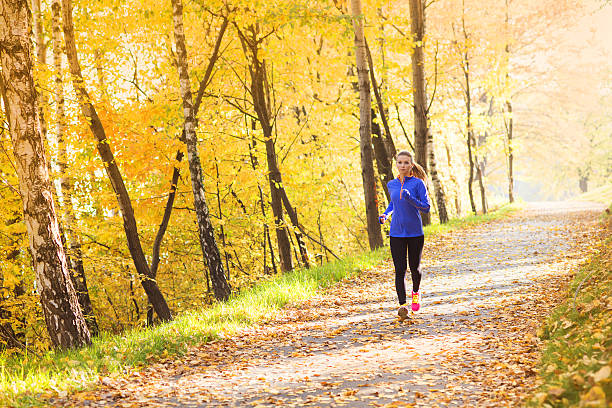 activa y deportivo mujer de corredor en otoño de la naturaleza - autumn women park forest fotografías e imágenes de stock