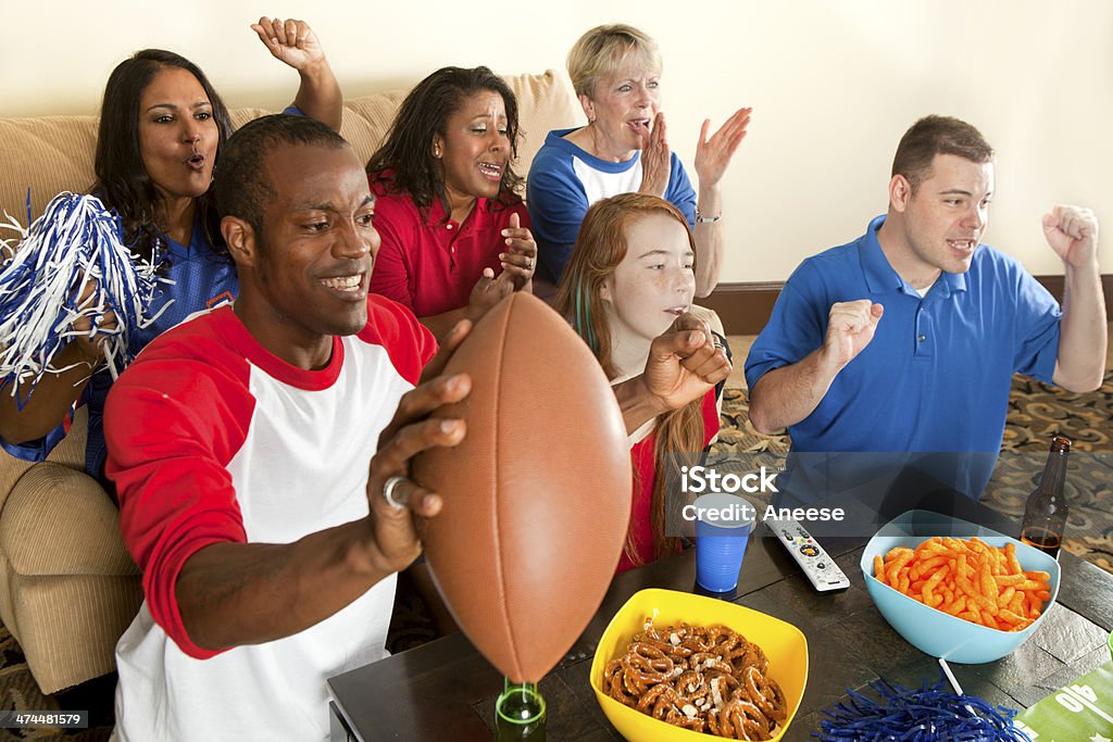 Diverse Group of Family and Friends Watching a Football Game Diverse group of family and friends watching and cheering for a team.  American Football - Ball Stock Photo