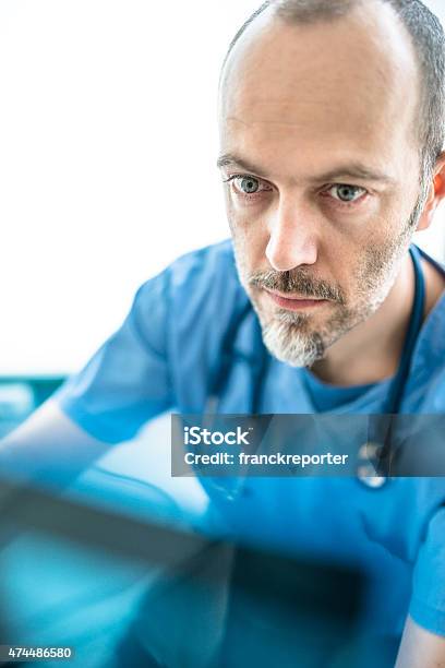 Pensive Doctor Looking The Xray Stock Photo - Download Image Now - 2015, 40-49 Years, Adult