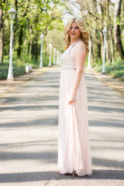 istock Blond woman in evening gown posing 474486886