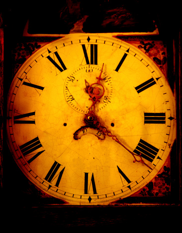 Vintage grandfather clock face that has a grunge feel and reads twenty past twelve.