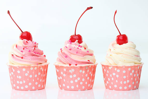 Cupcake with whipped cream and cherry isolated on white