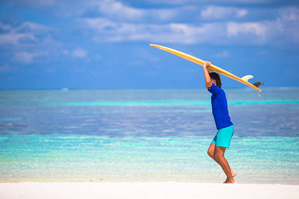 istock Happy young man surfing on the tropical coast 474488822