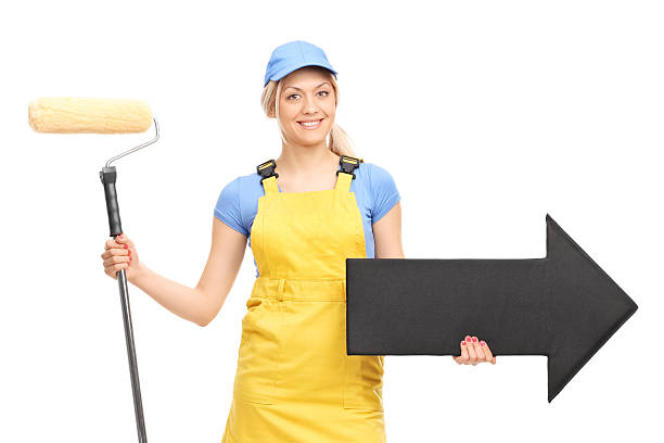 Female painter holding a paint roller and an arrow