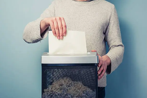 Man is shredding a piece of paper