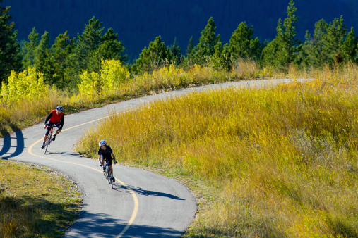 A father and son road bicycling on the Legacy Trail in Banff National Park, Alberta, Canada.
