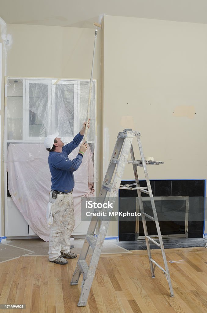 Professional house painter rolling a wall Adhesive Tape Stock Photo