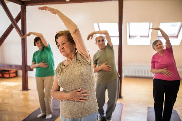 istock Group of seniors doing stretching exercises with their arms raised. 474499352