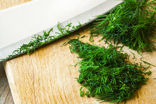 Chopping fresh dill with a curved mezzaluna knife