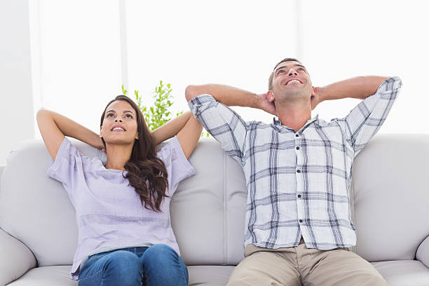 istock Couple with hands behind head sitting on sofa 474501274
