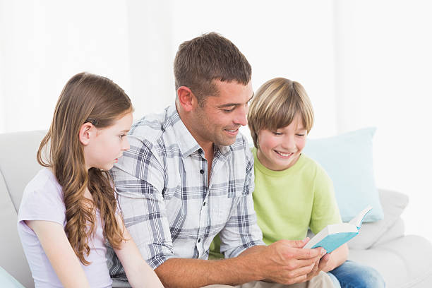 istock Man telling story to children while sitting on sofa 474502034