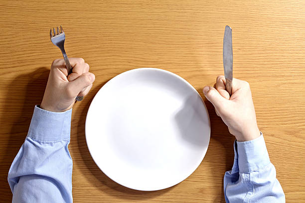 istock Boy a fork a knife sitting the table white  plate. 474502218