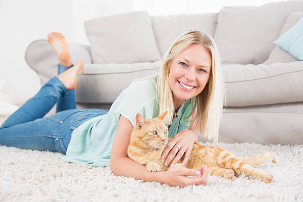 istock Happy woman with cat lying on rug 474502350
