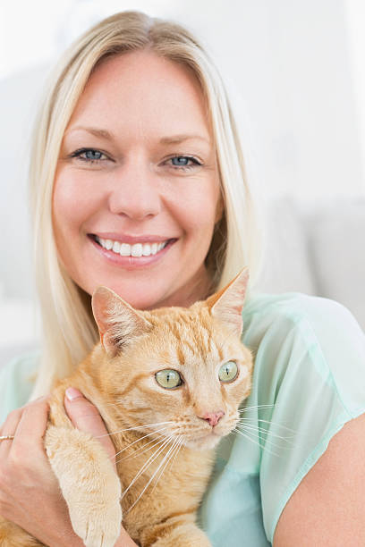 istock Woman holding cat at home 474502512