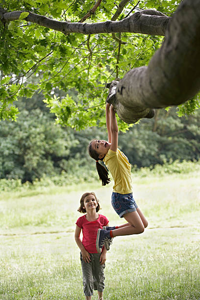 istock Girl Watching Friend Hanging From Tree 474503775