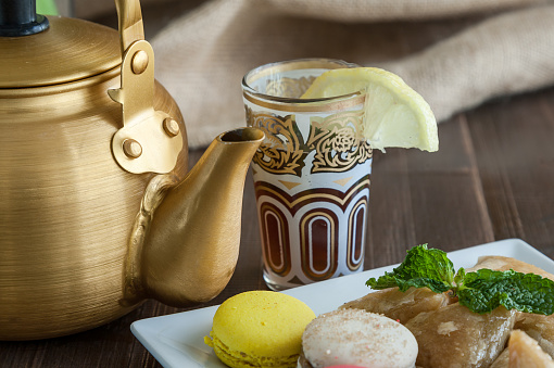 Arabian golden teapot on white wooden table