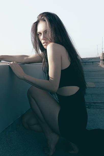 istock Sexy glamorous woman sitting on a rooftop 474504642