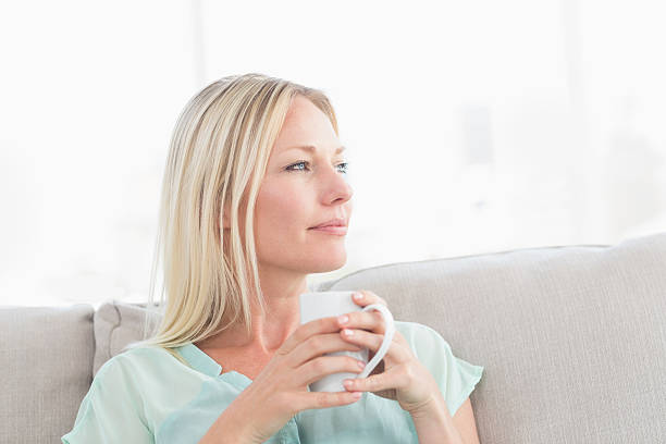 istock Woman holding coffee cup while looking away 474504670