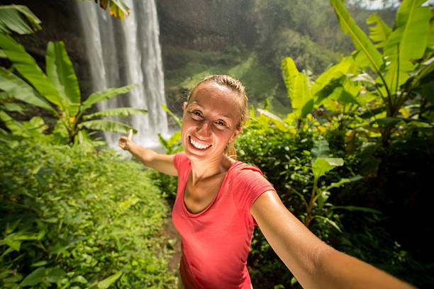 istock Woman taking selfie in jungle with waterfall 474505042